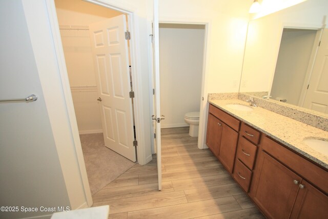 8342 Laguna Cir, Micco, FL 32976 - bathroom with wood finished floors, double vanity, toilet, and a walk in closet