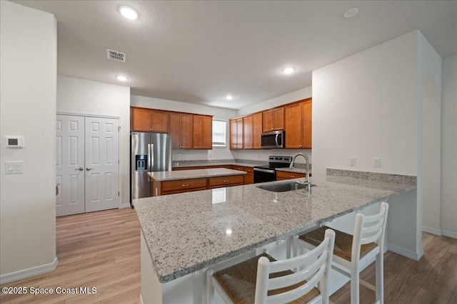 8342 Laguna Cir, Micco, FL 32976 - kitchen featuring stainless steel appliances, brown cabinets, a peninsula, baseboards, and recessed lighting