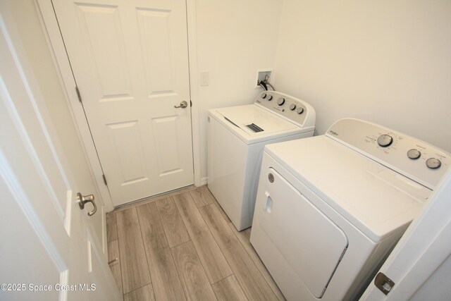 8342 Laguna Cir, Micco, FL 32976 - laundry area with washer and dryer and light wood-style flooring