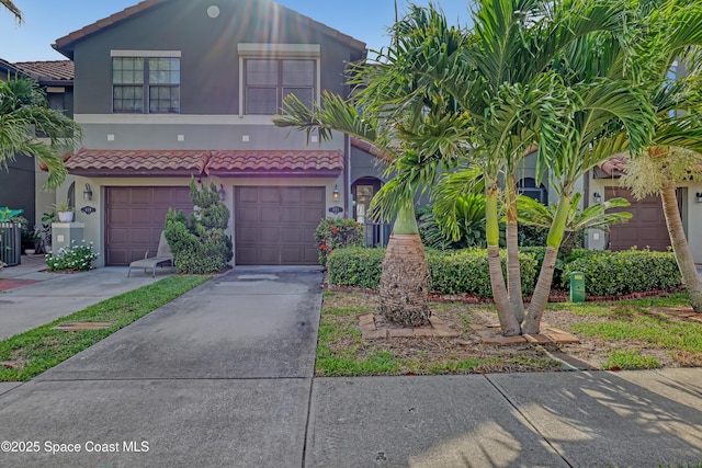 681 Ventura Dr, Satellite Beach, FL 32937 - view of front of home with stucco siding, a garage, concrete driveway, and a tile roof