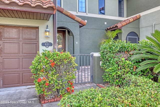 681 Ventura Dr, Satellite Beach, FL 32937 - property entrance featuring stucco siding, a garage, and a tile roof