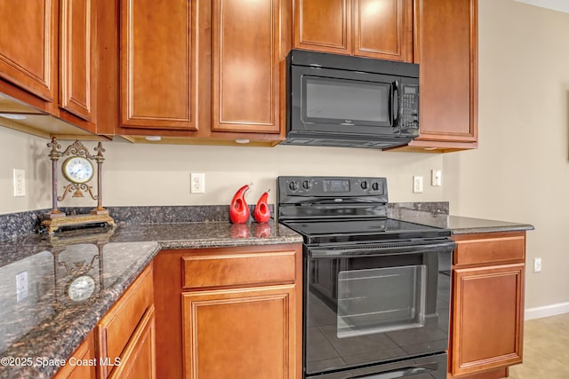 681 Ventura Dr, Satellite Beach, FL 32937 - kitchen featuring black appliances, dark stone countertops, brown cabinetry, and light tile patterned floors