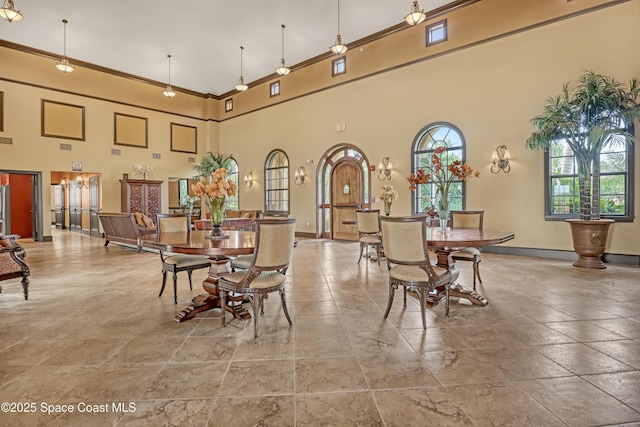 681 Ventura Dr, Satellite Beach, FL 32937 - dining room featuring a high ceiling, ornamental molding, and baseboards
