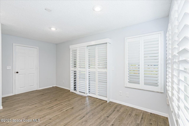 817 Seven Gables Cir SE, Palm Bay, FL 32909 - unfurnished bedroom featuring wood finished floors, baseboards, a textured ceiling, and recessed lighting