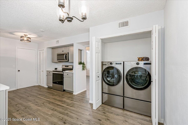 817 Seven Gables Cir SE, Palm Bay, FL 32909 - washroom featuring separate washer and dryer, wood finished floors, a chandelier, and a textured ceiling