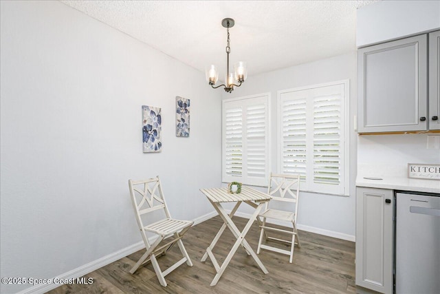 817 Seven Gables Cir SE, Palm Bay, FL 32909 - dining area with wood finished floors, a chandelier, baseboards, and a textured ceiling
