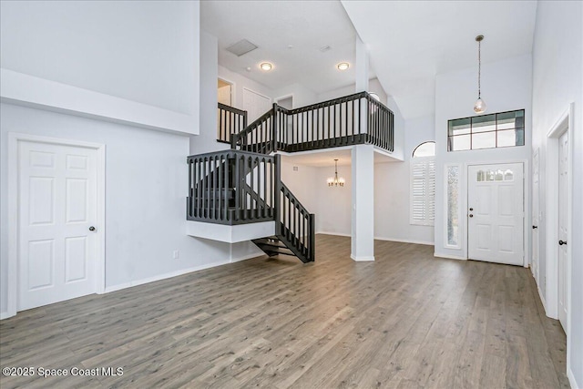 817 Seven Gables Cir SE, Palm Bay, FL 32909 - foyer entrance with high vaulted ceiling, stairs, wood finished floors, a chandelier, and baseboards