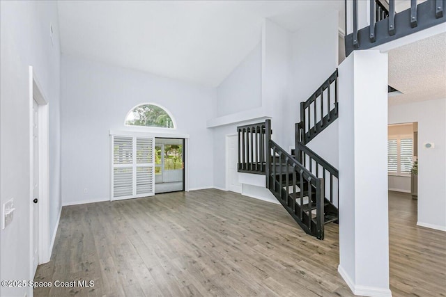 817 Seven Gables Cir SE, Palm Bay, FL 32909 - foyer featuring high vaulted ceiling, wood finished floors, stairway, and baseboards