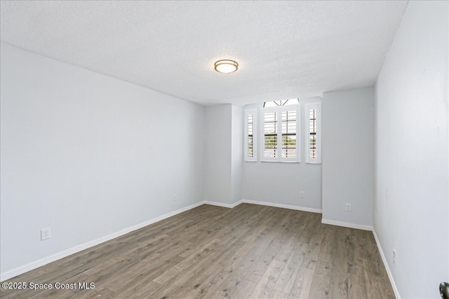 817 Seven Gables Cir SE, Palm Bay, FL 32909 - unfurnished room featuring wood finished floors, a textured ceiling, and baseboards