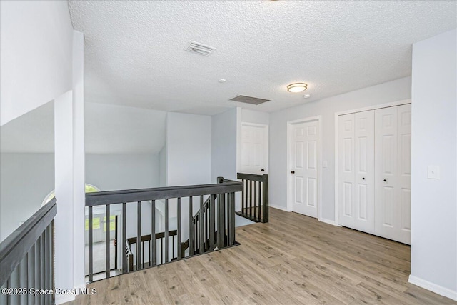 817 Seven Gables Cir SE, Palm Bay, FL 32909 - corridor featuring an upstairs landing, wood finished floors, baseboards, and a textured ceiling