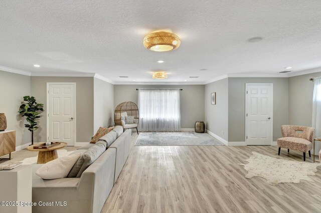 105 38th Ct, Vero Beach, FL 32968 - living area with healthy amount of natural light, a textured ceiling, baseboards, recessed lighting, and light wood-style floors