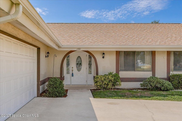 1181 Fairway Ct NE, Palm Bay, FL 32905 - doorway to property featuring an attached garage, roof with shingles, and stucco siding