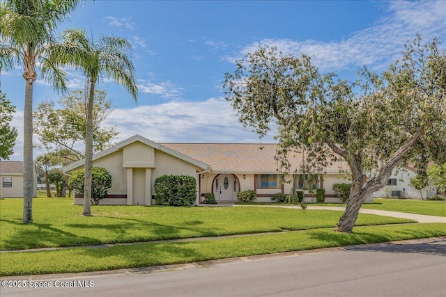 1181 Fairway Ct NE, Palm Bay, FL 32905 - view of front facade with stucco siding, a front lawn, and driveway