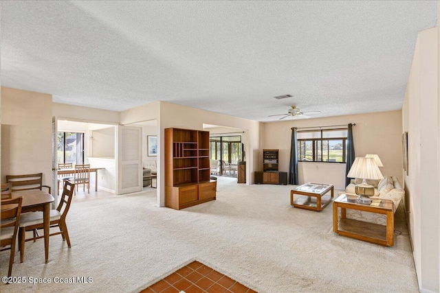 1181 Fairway Ct NE, Palm Bay, FL 32905 - living room featuring a textured ceiling, a ceiling fan, carpet, and tile patterned flooring