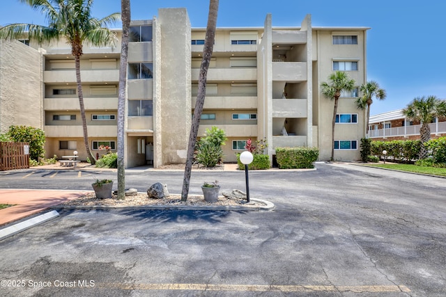 5050 Ocean Beach Blvd Unit 309, Cocoa Beach, FL 32931 - view of apartment building / complex featuring uncovered parking