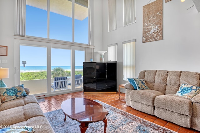 5050 Ocean Beach Blvd Unit 309, Cocoa Beach, FL 32931 - living area featuring tile patterned floors, a high ceiling, and a water view