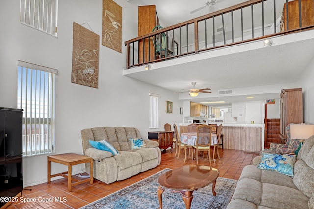 5050 Ocean Beach Blvd Unit 309, Cocoa Beach, FL 32931 - living area featuring a towering ceiling, ceiling fan, tile patterned floors, baseboards, and stairway