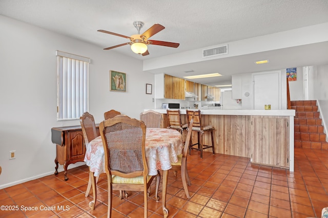 5050 Ocean Beach Blvd Unit 309, Cocoa Beach, FL 32931 - dining area featuring light tile patterned floors, ceiling fan, baseboards, and a textured ceiling