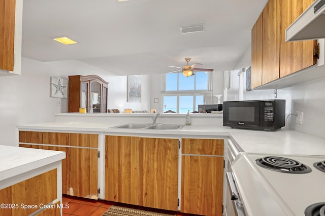 5050 Ocean Beach Blvd Unit 309, Cocoa Beach, FL 32931 - kitchen with black microwave, a sink, light countertops, under cabinet range hood, and ceiling fan
