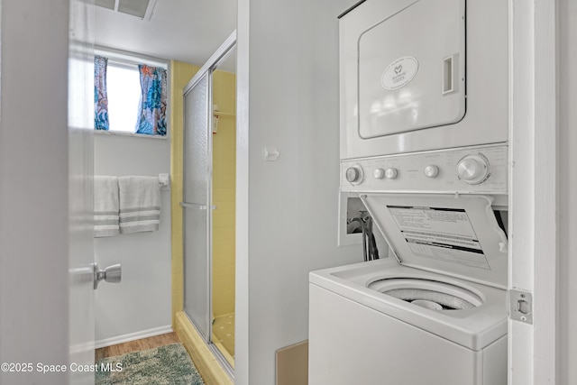 5050 Ocean Beach Blvd Unit 309, Cocoa Beach, FL 32931 - laundry room with estacked washer and dryer and wood finished floors