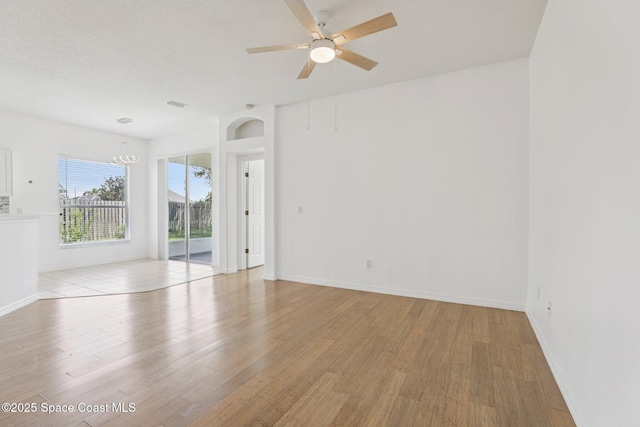 1609 Kestrel Ct, Rockledge, FL 32955 - unfurnished room with light wood-type flooring, ceiling fan, a chandelier, arched walkways, and baseboards