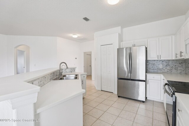 1609 Kestrel Ct, Rockledge, FL 32955 - kitchen with stainless steel appliances, a sink, light tile patterned flooring, white cabinets, and tasteful backsplash