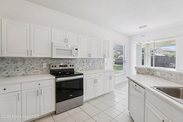 1609 Kestrel Ct, Rockledge, FL 32955 - kitchen with white appliances, backsplash, white cabinets, and a textured ceiling
