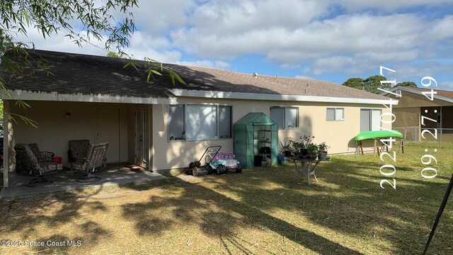 1241 Cambo Ct NE, Palm Bay, FL 32905 - rear view of property with a shingled roof and stucco siding