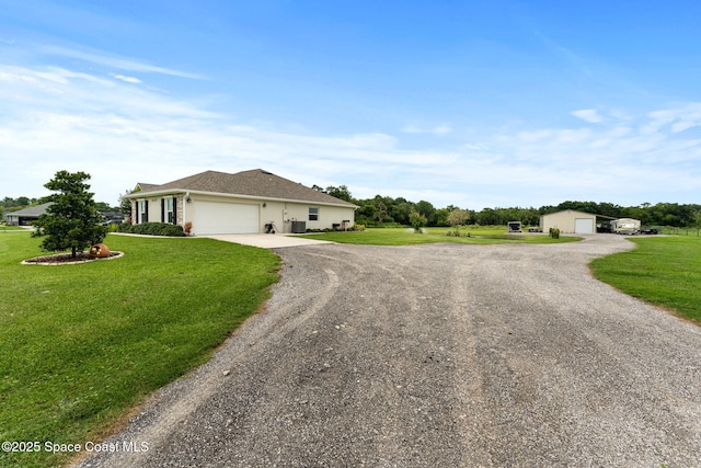 6435 Dixie Way, Mims, FL 32754 - view of front of home with a front yard, driveway, an attached garage, and an outbuilding