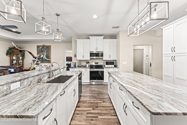 6435 Dixie Way, Mims, FL 32754 - kitchen with stainless steel appliances, a large island, a sink, dark wood-style flooring, and recessed lighting