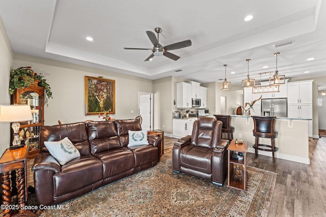6435 Dixie Way, Mims, FL 32754 - living room featuring a tray ceiling, ceiling fan, recessed lighting, dark wood-style floors, and baseboards