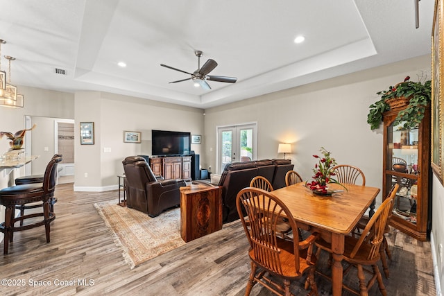 6435 Dixie Way, Mims, FL 32754 - dining area featuring a raised ceiling, light wood-type flooring, a ceiling fan, baseboards, and recessed lighting