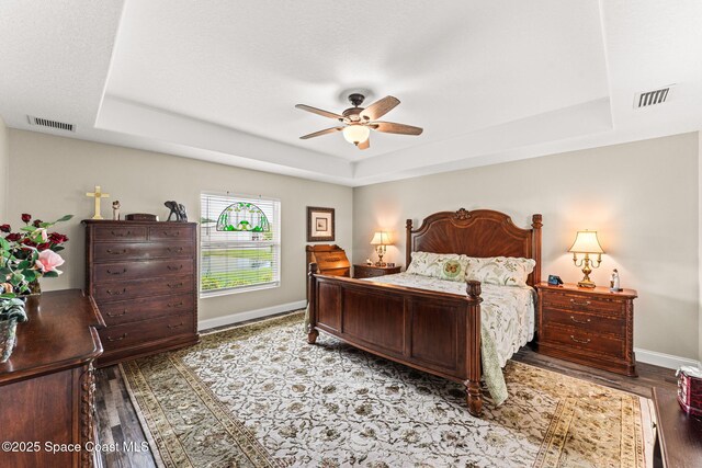 6435 Dixie Way, Mims, FL 32754 - bedroom with a raised ceiling, baseboards, wood finished floors, and ceiling fan