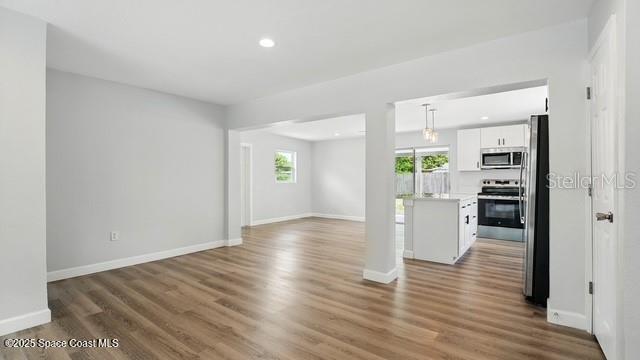 4415 Shaw Ave, Titusville, FL 32780 - unfurnished living room featuring baseboards, wood finished floors, and recessed lighting