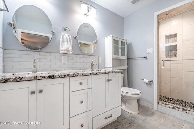 490 Candlestick Ave NE, Palm Bay, FL 32907 - bathroom featuring double vanity, backsplash, ceiling fan, toilet, and a tile shower