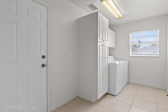 2829 SE Cabana Ln, Port St Lucie, FL 34952 - laundry room featuring washing machine and clothes dryer, cabinet space, light tile patterned floors, and baseboards