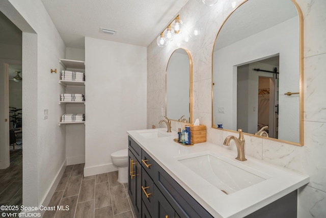 201 NE 3rd St, Satellite Beach, FL 32937 - full bath featuring double vanity, toilet, wood tiled floors, and tile walls