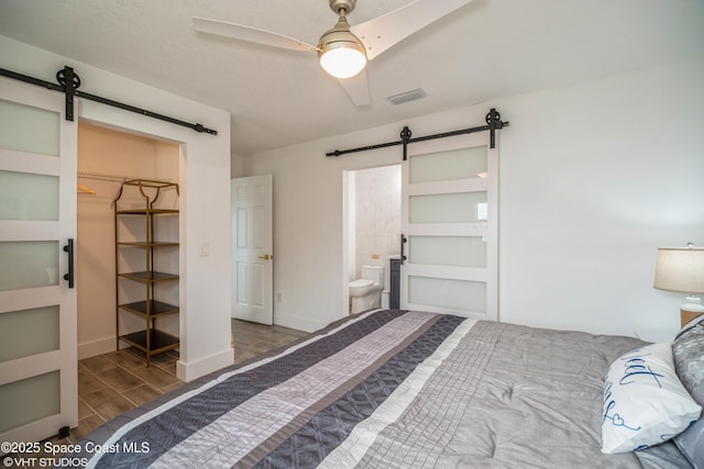 201 NE 3rd St, Satellite Beach, FL 32937 - bedroom featuring a barn door, wood finished floors, ensuite bathroom, and ceiling fan