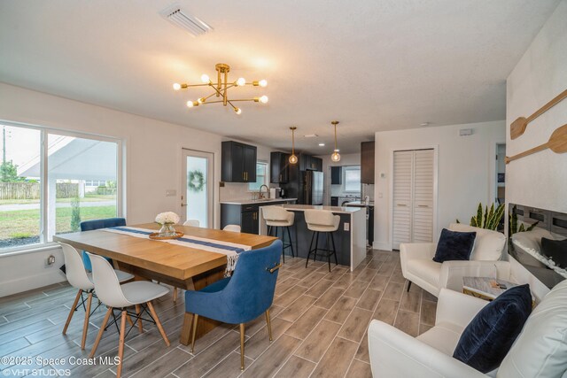 201 NE 3rd St, Satellite Beach, FL 32937 - dining room with a chandelier, wood finish floors, and baseboards