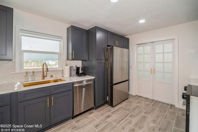 201 NE 3rd St, Satellite Beach, FL 32937 - kitchen featuring appliances with stainless steel finishes, a sink, decorative backsplash, french doors, and light countertops