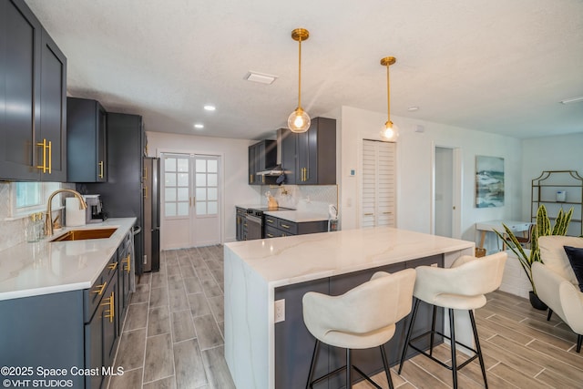 201 NE 3rd St, Satellite Beach, FL 32937 - kitchen featuring a sink, electric range, wood finish floors, a breakfast bar area, and decorative backsplash