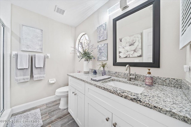 977 Osprey Dr, Melbourne, FL 32940 - bathroom featuring wood finished floors, toilet, vanity, baseboards, and a stall shower