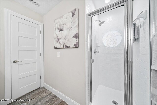 977 Osprey Dr, Melbourne, FL 32940 - full bath with wood finished floors, a stall shower, and baseboards