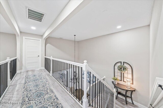 977 Osprey Dr, Melbourne, FL 32940 - corridor featuring an upstairs landing, wood finished floors, baseboards, and recessed lighting