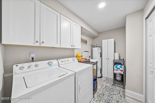 977 Osprey Dr, Melbourne, FL 32940 - washroom featuring washing machine and clothes dryer, light wood-style floors, cabinet space, electric water heater, and baseboards
