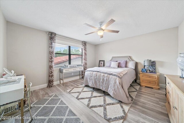 977 Osprey Dr, Melbourne, FL 32940 - bedroom with light wood-style floors, baseboards, a textured ceiling, and ceiling fan