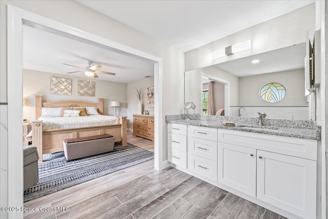 977 Osprey Dr, Melbourne, FL 32940 - ensuite bathroom with vanity, a ceiling fan, and wood finished floors