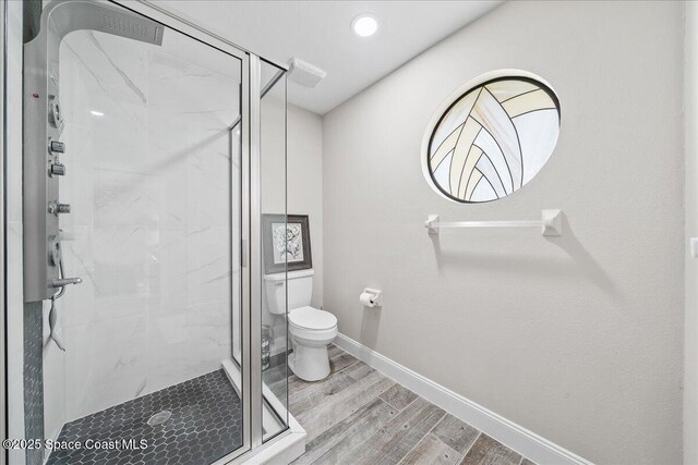 977 Osprey Dr, Melbourne, FL 32940 - full bathroom featuring wood finished floors, toilet, a marble finish shower, and baseboards