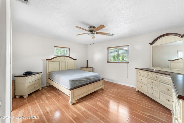 790 Alfonso Ave SE, Palm Bay, FL 32909 - bedroom with multiple windows, light wood-style flooring, a textured ceiling, baseboards, and a ceiling fan