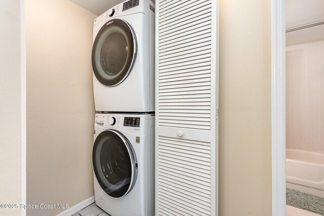 1600 Woodland Dr Unit 4105, Rockledge, FL 32955 - laundry area featuring stacked washer / dryer, light tile patterned flooring, and baseboards
